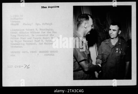 Tenente Robert E. Hattingly, ufficiale degli affari civili per il distretto di Boa Vang, ricevendo le medaglie Silver Star e Purple Heart dal maggiore generale Wood B. Kyle, comandante generale della 3rd Marine Division, il 6 ottobre 1966. Questa fotografia cattura la cerimonia durante la guerra del Vietnam. Foto Stock