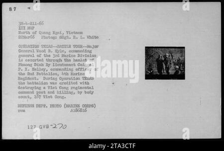 Il maggiore generale Wood B. Kyle, comandante generale della 3rd Marine Division, è scortato dal tenente colonnello P. X. Kelley, comandante del 2nd Battalion, 4th Marine Regiment, attraverso il villaggio di Phuong Dinh durante l'operazione TEXAS. Il battaglione ottenne un significativo successo durante l'operazione, compresa la distruzione di un posto di comando del reggimento Viet Cong e circa 167 Viet Cong uccisi. (Foto del Dipartimento della difesa del 22 marzo 1966) Foto Stock