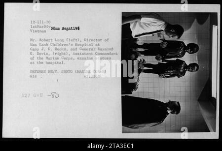 Il direttore dell'Hoa Kanh Children's Hospital, il signor Robert Long, e il generale Raymond G. Davis, Assistente Comandante del corpo dei Marines, esaminano le statue dell'ospedale in Vietnam. Questa fotografia è stata scattata nel 1970 durante le cerimonie a Camp J. K. Books, e fa parte delle attività della 1st Marine Division. Foto Stock