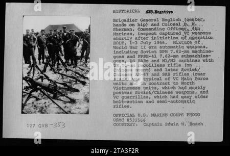 Il Brigadier generale English e il colonnello D.W. Sherman ispezionano le armi catturate durante l'operazione HOLT dal 1 al 2 luglio 1966. Le armi includevano armi automatiche dell'era della seconda guerra mondiale come mitragliatrici sovietiche DPM da 7,62 mm e mitragliatrici PPSH-41 7,62 mm, BARRE statunitensi e carabine M1/m2, un fucile senza rinculo da 75 mm statunitense su un supporto cinese, così come i successivi fucili sovietici/cinesi AK-47 e SKS. Le armi catturate sono state attribuite alle unità della VC Main Force. Questa fotografia ufficiale fa parte della collezione del capitano Edwin W. Besch (USMC n. 532566). Foto Stock