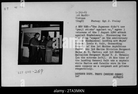 Il maggiore generale Lewis W. Walt, comandante generale della 3rd Marine Amphibious Force; il sergente maggiore H. D. Parice della 3rd Marine Division; e il sergente maggiore E. J. Catallo del 3rd Medical Battalion discutono dell'uso dei bastoni panji da parte dei Viet Cong, paragonandolo all'attacco di Guadalcanal nel 1942. Foto scattata il 7 agosto 1965, durante la guerra del Vietnam." Foto Stock