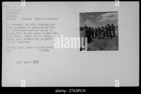 Soldato AMERICANO che istruisce i Chou Hot "Kit Carson Scout" sulla corretta posizione prona prima di portarli al raggio d'azione per sparare il fucile M-16. Un alto sottufficiale osserva mentre il soldato fornisce la spiegazione. 24 maggio 1967, durante le attività della 3a Divisione Marina in Vietnam. A288689 127 GVB-3/8 (foto del Dipartimento della difesa - corpo dei Marines). Foto Stock