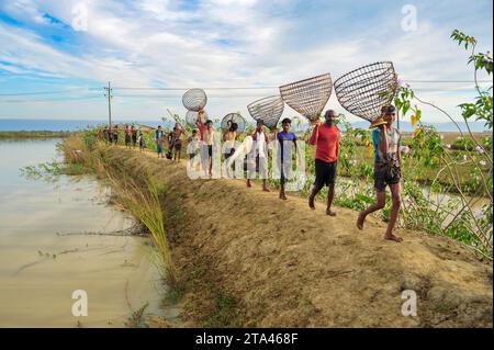 28 novembre 2023 Sylhet-Bangladesh: Le persone rurali armate di trappole di pesce di bambù e reti prendono parte a festeggiare in un festival invernale di pesca di 200 anni al jofra beel of gasbari union of Kanaighat upazila di Sylhet, Bangladesh. Il 28 novembre 2023 Sylhet, Bangladesh (foto di Rafayat Haque Khan/ Eyepix Group/Sipa USA) Foto Stock