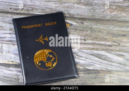 Libretto di passaporto nero con un aereo e la terra del globo sulla copertina, concetto di viaggio e turismo, libretto di passaporto universale per proteggere il passaporto Identit Foto Stock