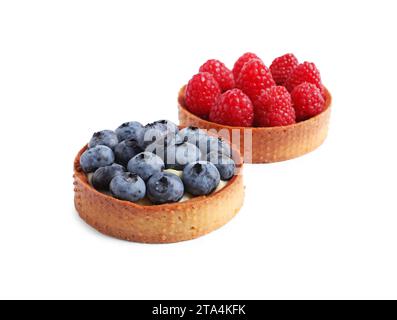 Tartarughe con bacche fresche diverse isolate su bianco. Delizioso dessert Foto Stock