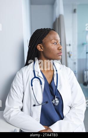 Medico donna afroamericana che indossa il cappotto da laboratorio e lo stetoscopio nella stanza d'ospedale Foto Stock