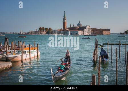 Serene gondole di Venezia: Tradizionali barche a remi in acque calme in Italia Foto Stock