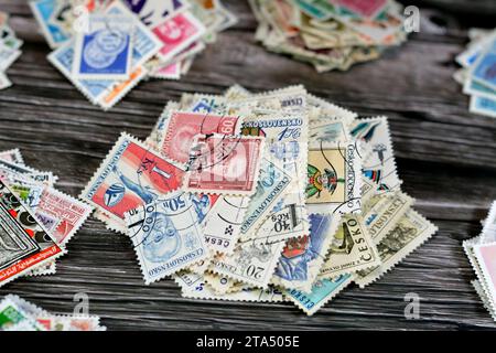 Cairo, Egitto 21 settembre 2022: Sfondo di vari vecchi francobolli usati da diversi paesi e tempi su sfondo di legno, con copertina Foto Stock