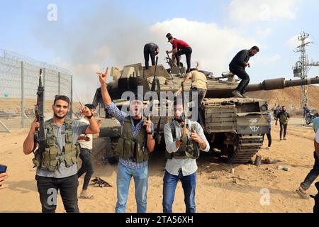 Rafah, Gaza. 7 ottobre 2023. I palestinesi prendono il controllo di un carro armato israeliano dopo aver attraversato la recinzione di confine con Israele da Khan Yunis nella Striscia di Gaza meridionale sabato 7 ottobre 2023. All'alba, dalla Striscia di Gaza sono stati lanciati attacchi di razzi contro Israele mentre i militanti dell'enclave palestinese bloccata si infiltravano in Israele. Foto di Ismael Mohamad/UPI. Crediti: UPI/Alamy Live News Foto Stock