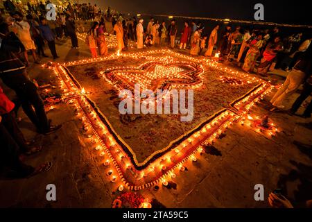 Varanasi, India. 27 novembre 2023. Gli indù indiani dedica le luci mentre prega Dio alla vigilia di Dev Deepavali. Dev Deepavali, noto anche come Diwali degli dei, è un festival celebrato a Karthik Purnima, che cade 15 giorni dopo Diwali. Dev Deepavali è il più grande Festival della luce dell'India dove i devoti decorano la riva del fiume Gange con milioni di lampade come parte del festival. Credito: SOPA Images Limited/Alamy Live News Foto Stock