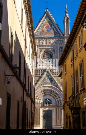 Orvieto, Italia - 18 novembre 2023: Vista verticale delle strette strade di Orvieto con la guglia del Duomo di Orvieto alle spalle Foto Stock