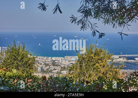 Haifa, Israele - 22 ottobre 2023: Porto marittimo nella città di Haifa, panorama del porto e degli edifici cittadini sullo sfondo di un cielo blu con clou Foto Stock