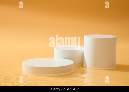Un set di tre podi bianchi disposti in forme geometriche. Presentazione di prodotti cosmetici per piattaforme. Sfondo arancione per i prodotti di bellezza Foto Stock