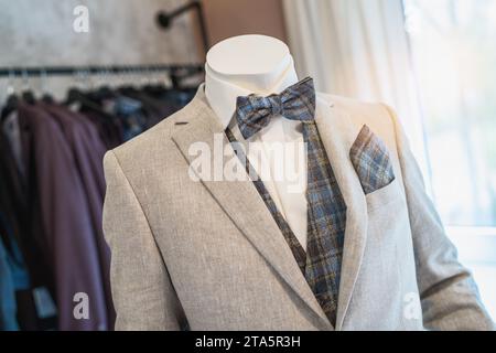 Manichino vestito in grigio chiaro con cravatta a quadri e tasca quadrata coordinata in un negozio nuziale Foto Stock