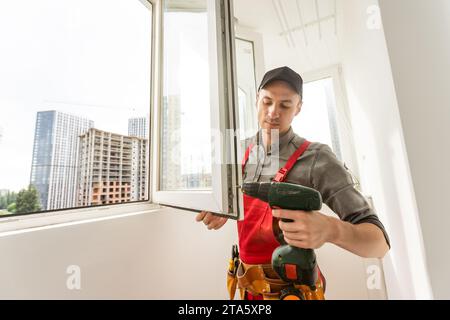 master mette una nuova finestra a doppio vetro in una finestra di plastica Foto Stock