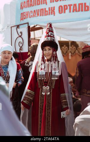 SHYMKENT, KAZAKISTAN - 22 MARZO 2023: Ragazza kazaka in costume tradizionale festivo kazako alla celebrazione di Nauryz Foto Stock