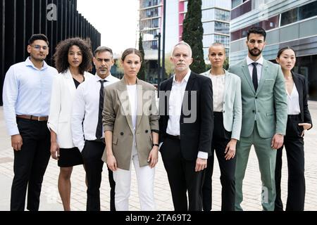 Gruppo multietnico di uomo d'affari e donna d'affari che fissa la telecamera team esecutivo multirazziale fiducioso in strada. Foto Stock