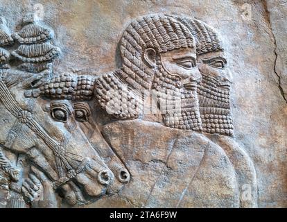 Londra, Regno Unito - 18 aprile 2022: Scultura in pietra assira dal Palazzo centrale di Nimrud, raffigurante un carro reale. Risalente al 725 a.C. British Museu Foto Stock