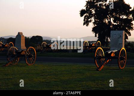 Il sole tramonta sui cannoni, l'artiglieria e i monumenti del Gettysburg National Military Park, sito della battaglia della guerra di secessione americana Foto Stock