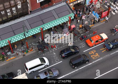 TOKYO, GIAPPONE - 4 DICEMBRE 2016: Pedoni, automobili e conducenti di risciò condividono la strada di Asakusa a Tokyo, Giappone. Foto Stock