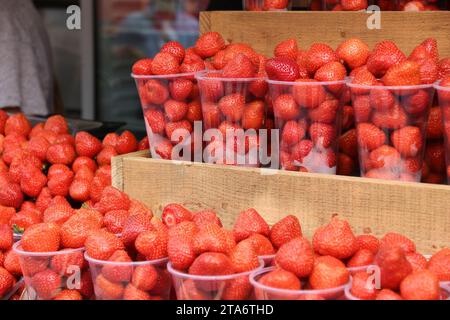 Tazze di plastica alla fragola in un mercato alimentare di Londra, Regno Unito. Foto Stock