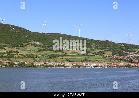 Coronini Village & Moldova Noua onshore turbine eoliche farm sulla collina, lato rumeno del Danubio, confine con la Serbia, Romania energia elettrica Foto Stock