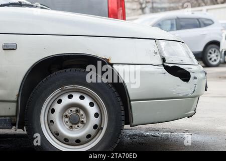 Corrosione della lamiera sulla ruota della vecchia auto bianca. Superficie arrugginita e disordinata. Grana sporca danneggiata dal sale della strada. Sfondo ruggine. Protezione di a Foto Stock