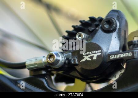 Il freno della Mountain bike Shimano viene frenato su sfondo sfocato Foto Stock