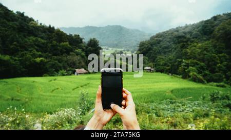 Prospettiva personale di fotografare Chiang mai, Thailandia. Mano femminile con primo piano dello smartphone. Scattare foto sullo smartphone mentre si è in viaggio. Delightf Foto Stock