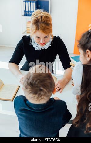 Formazione degli insegnanti degli scolari in una lezione scolastica in classe Foto Stock