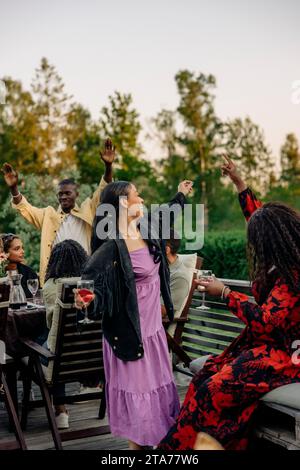 Amici allegri che ballano durante la festa nel cortile sul retro Foto Stock