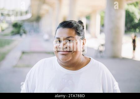 Ritratto di una donna oversize sorridente che indossa una t-shirt bianca Foto Stock
