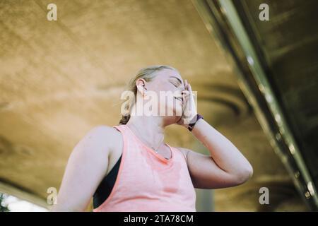 Vista dall'angolo basso di una donna matura stanca dopo l'allenamento Foto Stock