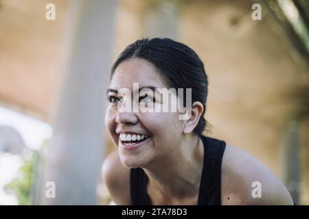 Donna felice che ride mentre si fa esercizio Foto Stock