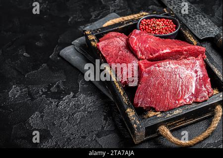 Crudo veleno crudo crudo caro carne, carne di selvaggina. Sfondo nero. Vista dall'alto. Copia spazio. Foto Stock