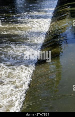 Una piccola diga su un fiume con un piccolo volume d'acqua Foto Stock