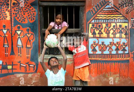 I bambini del villaggio rurale giocano davanti alla loro bella casa nel Bengala Occidentale in India. Foto Stock