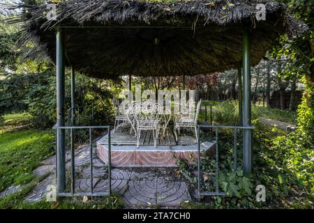 Piazza in un giardino con un gazebo di metallo dipinto di bianco Foto Stock