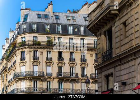 Scorcio di un tipico ed elegante edificio residenziale nel centro di Parigi, in Francia, con ringhiere in ferro battuto e balconi Foto Stock