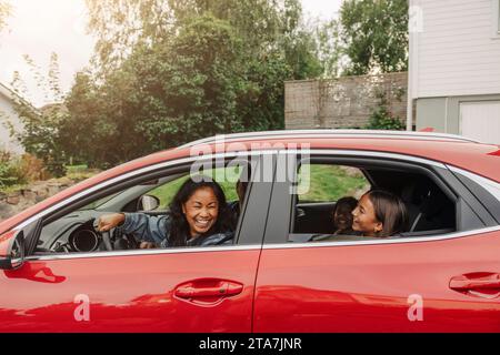 La famiglia si diverte in auto elettrica durante il viaggio in auto Foto Stock