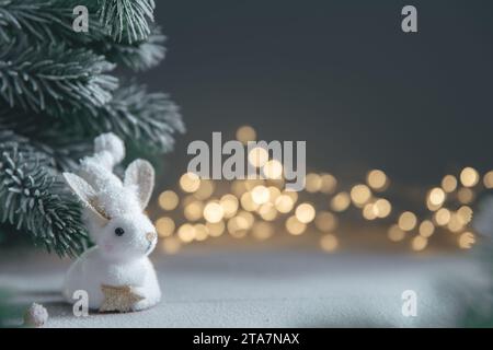 Un coniglio simbolo di 2023 tra le luci, ghirlande, alberi di Natale, calendario cinese anno simbolo con spazio copia Foto Stock