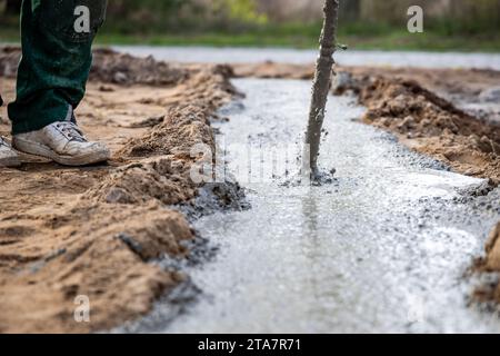 Testa vibrante per calcestruzzo che compatte le fondamenta in un cantiere edile Foto Stock