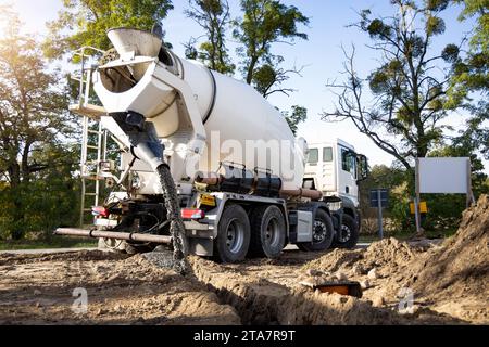 Betoniera che versa calcestruzzo in un cantiere edile Foto Stock