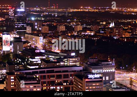 Le facciate di vetro di un grattacielo moderno di notte. Moderno ufficio in vetro in città. Grandi finestre luminose nei moderni edifici di uffici di notte. Nelle file di Foto Stock