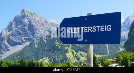 Il cartello di Klettersteig (via ferrata in tedesco) punta verso una montagna. Avventura, sport, attivo, europa, estate. Foto Stock