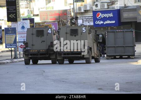 I veicoli militari corazzati entrano nel campo profughi di Jenin mentre le forze israeliane compiono raid nel campo profughi di Jenin i veicoli militari corazzati entrano nel campo profughi di Jenin mentre le forze israeliane compiono raid nel campo profughi di Jenin, Cisgiordania, il 29 novembre 2023. Foto di Mohammed Nasser apaimages Jenin Cisgiordania territorio palestinese 291123 Jenin MN 0013 Copyright: XapaimagesxMohammedxNasserxxapaimagesx credito: Imago/Alamy Live News Foto Stock