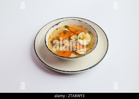 Ciotola di brodo con morbido filetto di pollo con uovo isolato su sfondo bianco. Ora di pranzo. Foto Stock