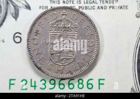Il lato inverso di 1 uno scellino Elisabetta II 1957 presenta uno scudo d'armi inglese coronato che divide la data, la leggenda sopra, la denominazione sotto, su un Ameri Foto Stock