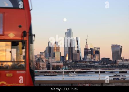 Luna piena sui grattacieli della città di Londra dal Waterloo Bridge, in inverno, al sole, Regno Unito Foto Stock