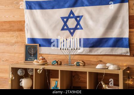 Armadietto in legno con decorazioni tradizionali Hanukkah e bandiera israeliana nel soggiorno Foto Stock
